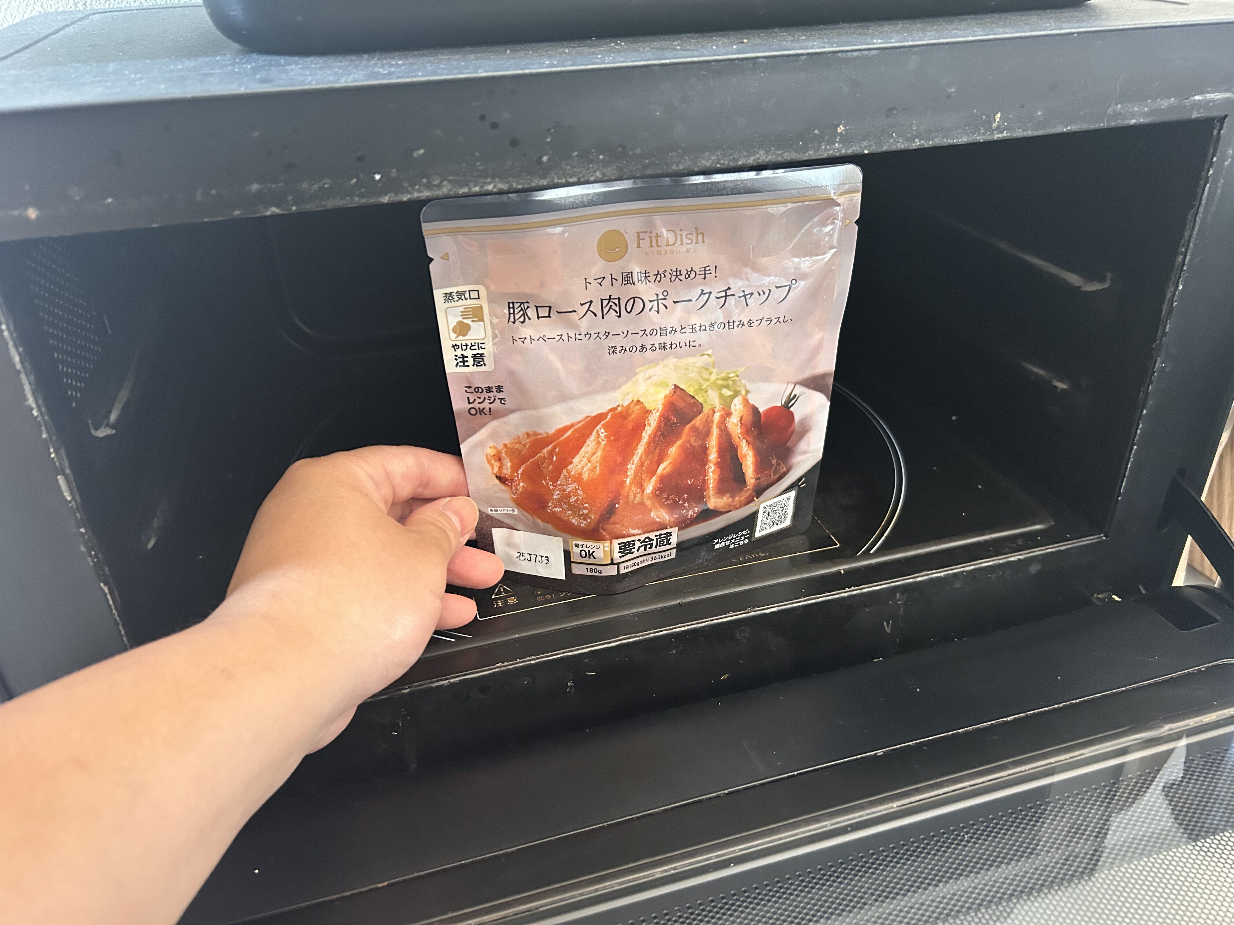 FitDish(フィットディッシュ)豚ロース肉のポークチャップをパウチのまま電子レンジで温める様子