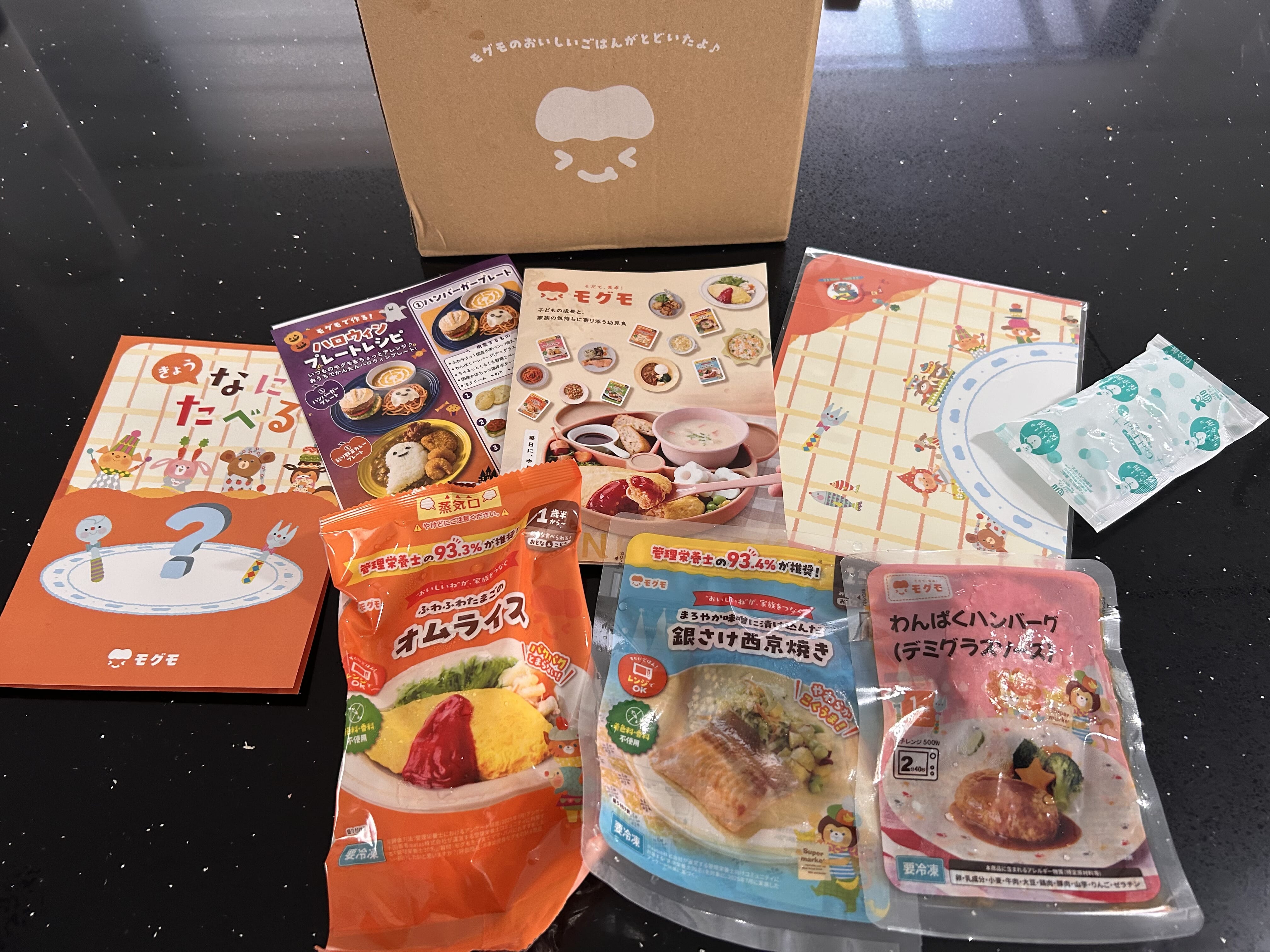 モグモの箱から出した3品と保冷剤、メニュー表などの同梱物